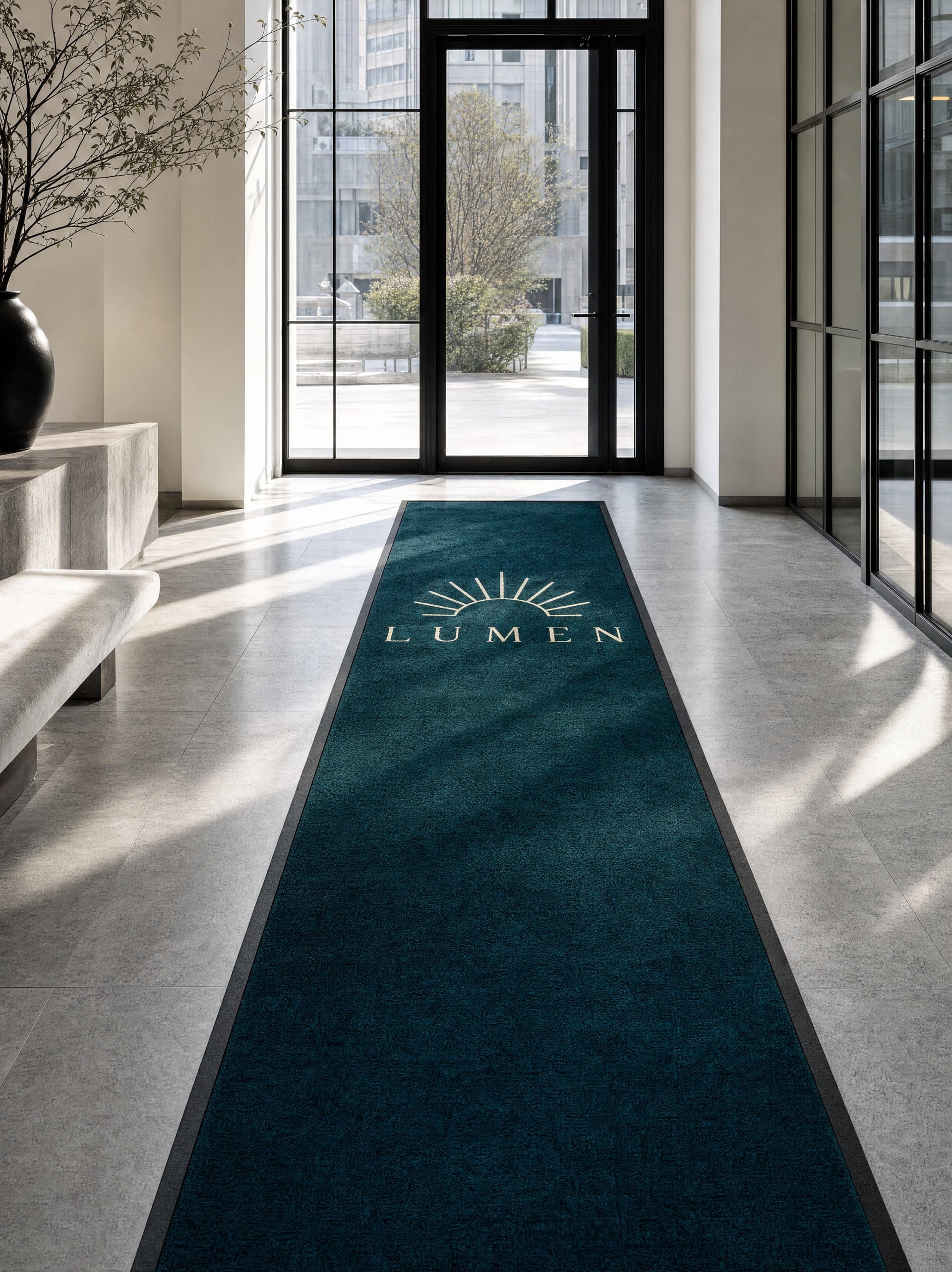 Long tapis de couloir bleu canard au logo crème dans le hall d’un hôtel