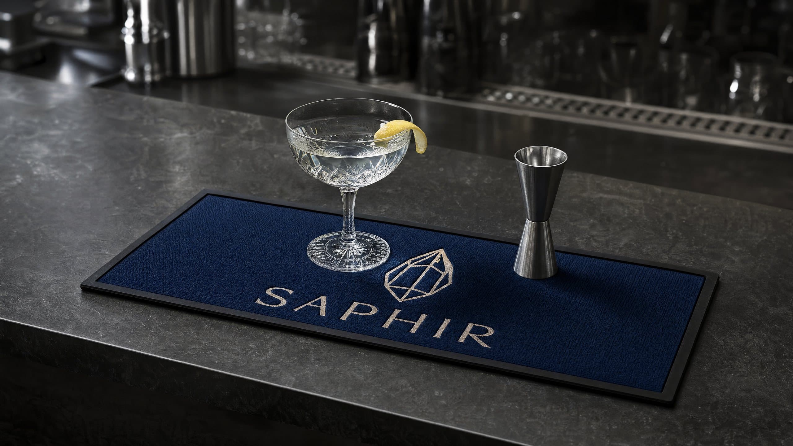 Tapis de bar bleu saphir à bordure noire sous un cocktail, dans un bar