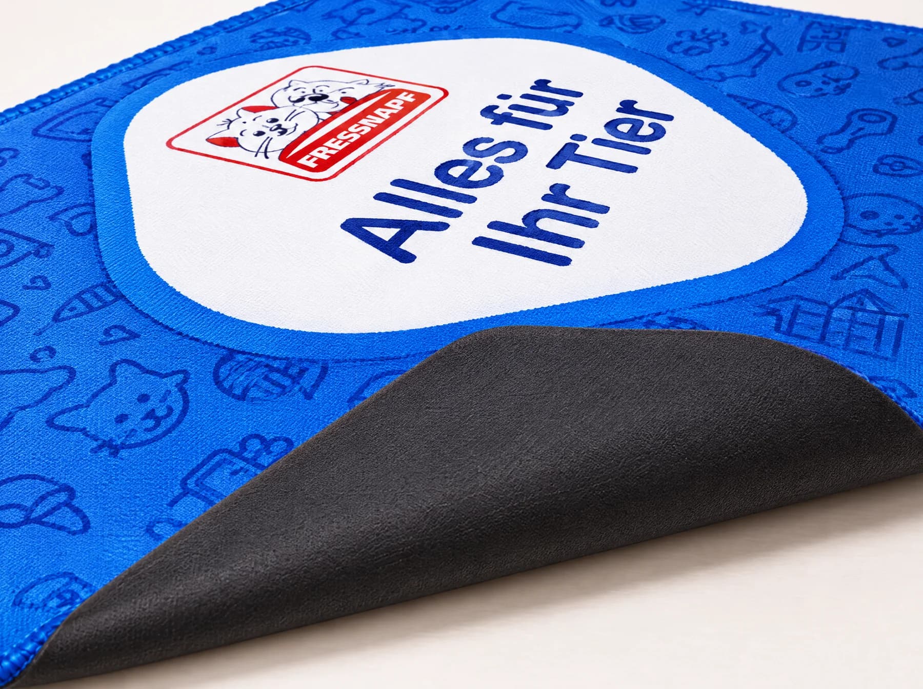 Illustration : Tapis de souris Standard bleu avec coin relevé montrant le dos noir