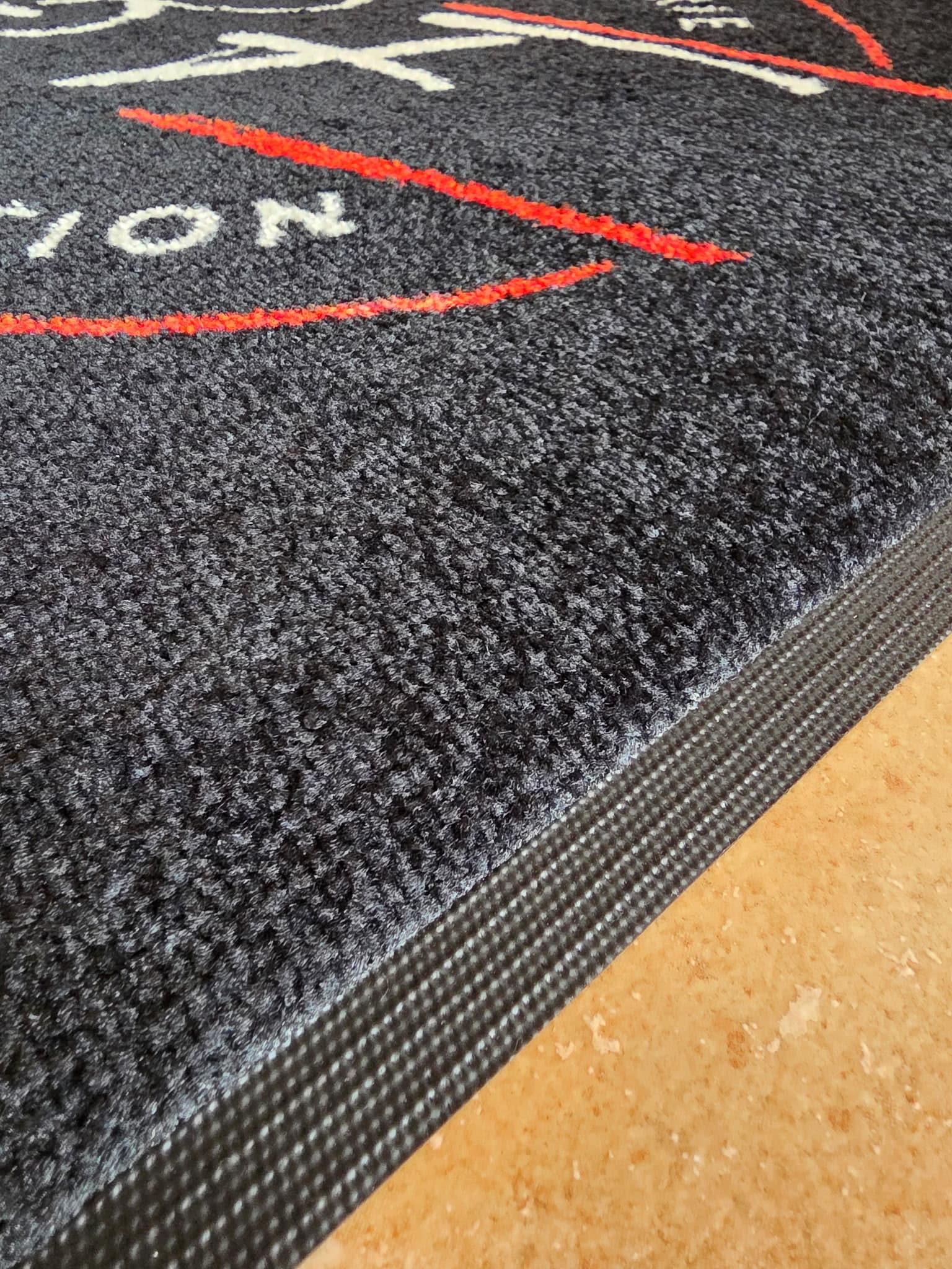 Détail de la surface anthracite et de la bordure noire du tapis Colorstar de Bertrand