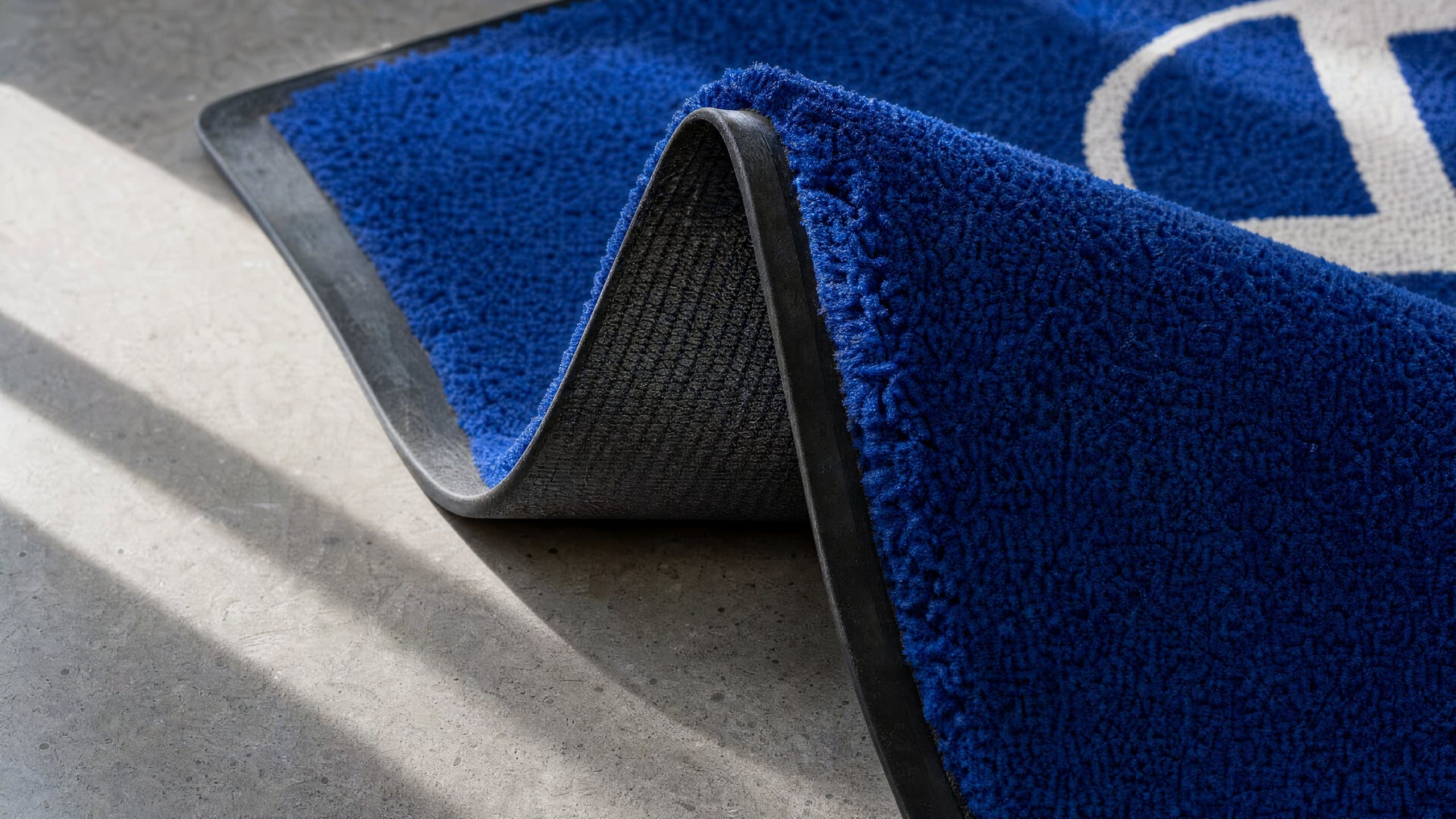 Coin retourné d’un tapis Colorstar bleu : poil épais et dos en caoutchouc nitrile noir